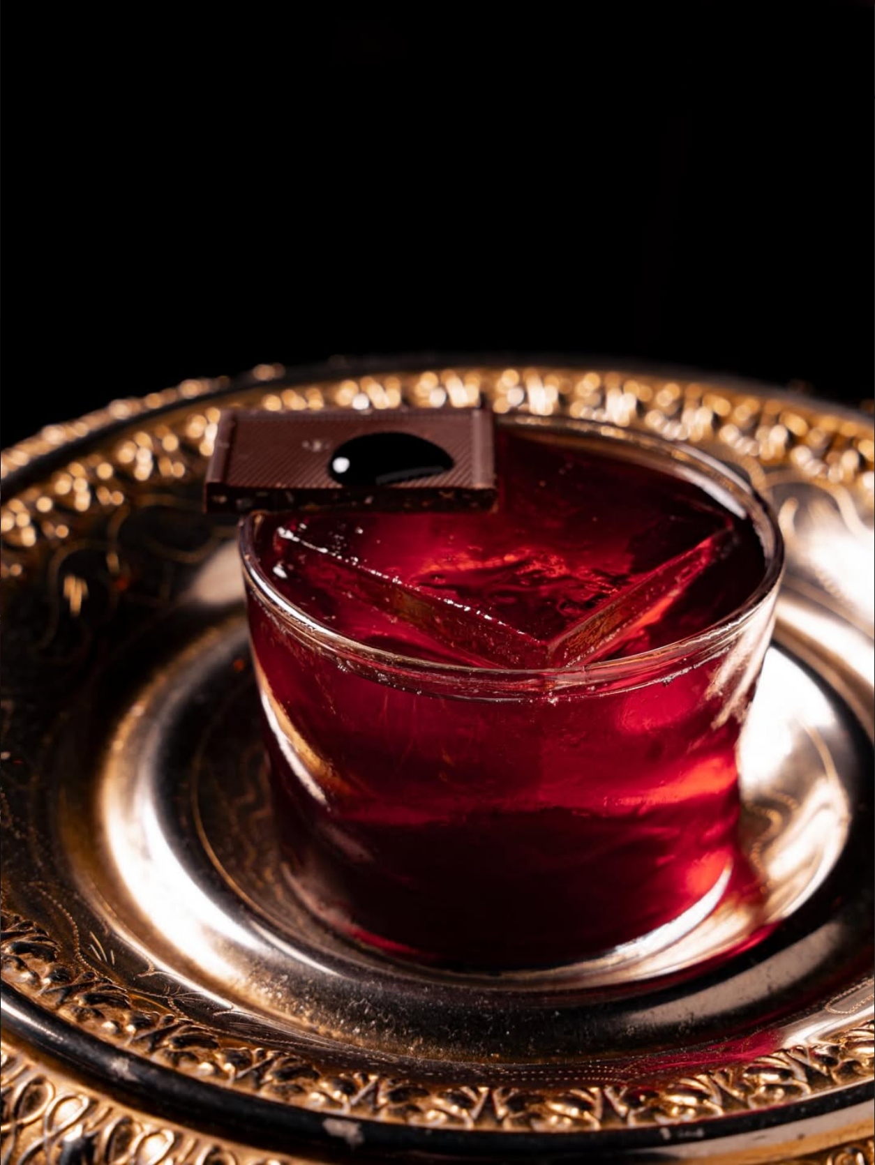 Ein Barkeeper vollendet einen Cocktail mit einer Olive